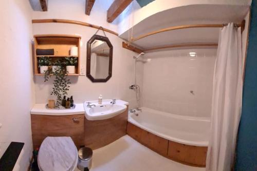 a bathroom with a tub and a sink and a toilet at Bramblewick Cottage in Robin Hood's Bay