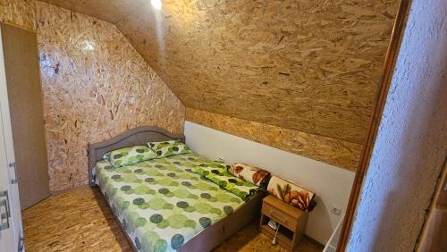 Vikendica Gojković في Skender Vakuf: غرفة نوم صغيرة مع سرير في جدار حجري
