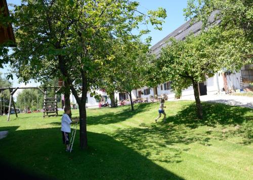 two children playing in a park with trees at Weinbachbauer - Urlaub am Bauernhof in St. Wolfgang