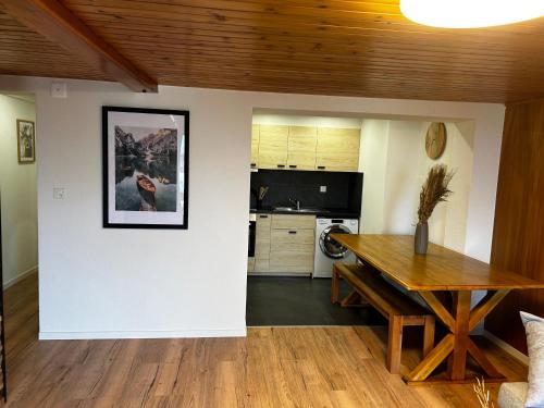 a living room with a table and a kitchen at SNOW NEST: Superbe cocon enneigé in Crans-Montana
