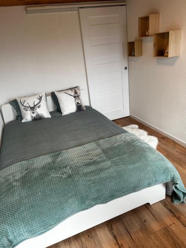 a bedroom with a bed with a green comforter at SNOW NEST: Superbe cocon enneigé in Crans-Montana