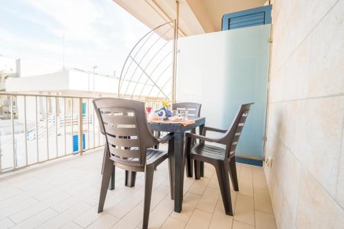 a table and two chairs on a balcony at CapoSud - Appartamento Salgari in Marina di Ragusa