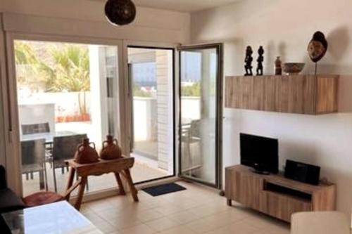 a living room with a tv and a sliding glass door at Villa Hélice - Moderno apartamento en Cabo de Gata in Las Negras