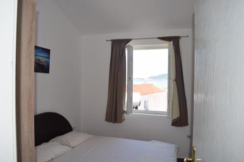 een slaapkamer met een bed en een raam bij Apartment Vidakovic in Budva