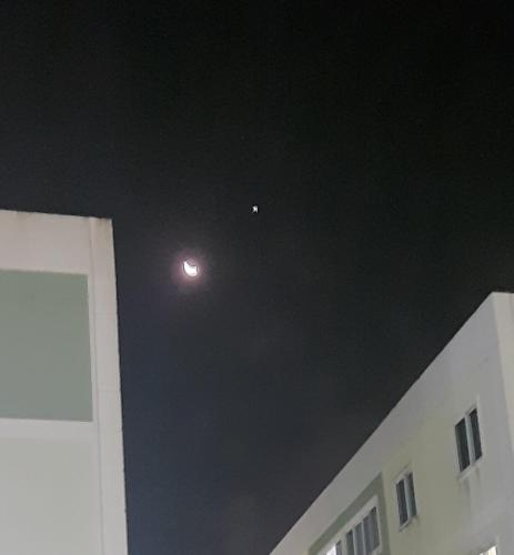 Ein Mond am Himmel über einem Gebäude in der Nacht in der Unterkunft Apto familiar para Semana Santa in Garanhuns