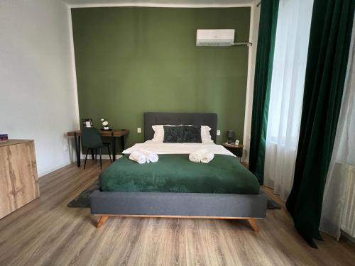 a bedroom with a bed and a green wall at Homeland Center Cluj in Cluj-Napoca