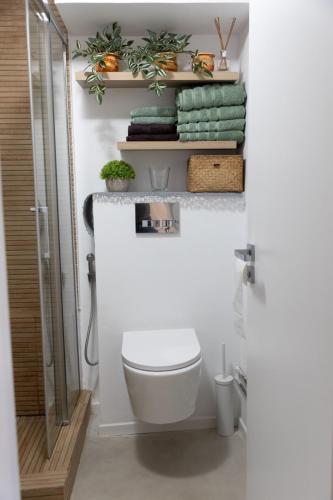 a bathroom with a toilet and some plants and towels at Sweet cozy Ultracentral in Craiova