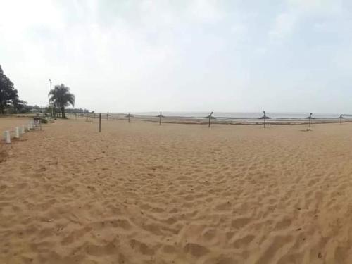 a sandy beach with a fence in the distance at Alojamiento Los Imigrantes in Chajarí