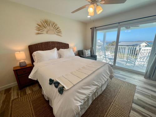 a bedroom with a large bed and a balcony at Family Tides on LGI - Golf Cart Included in Placida