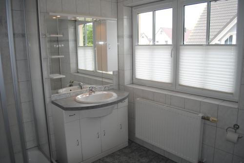 a white bathroom with a sink and a mirror at Haus Granitzhof in Binz