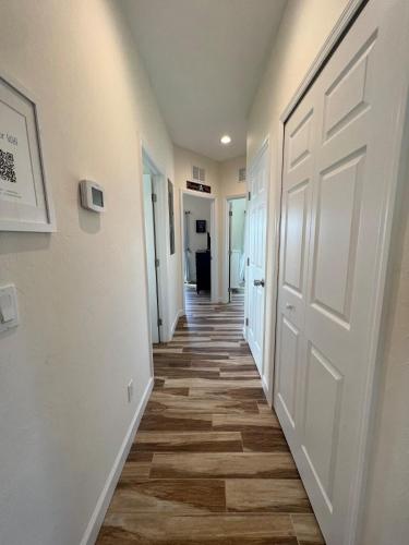 a hallway with a white door and wooden floors at Family Tides on LGI - Golf Cart Included in Placida