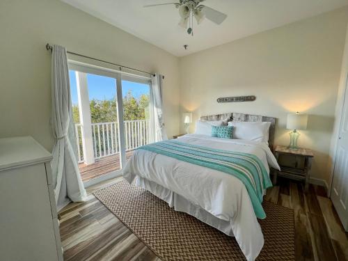 a bedroom with a bed and a large window at Family Tides on LGI - Golf Cart Included in Placida
