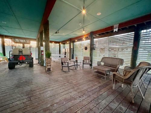 a large deck with furniture and a room with windows at Family Tides on LGI - Golf Cart Included in Placida