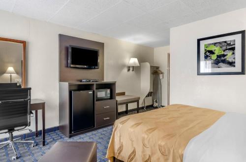 a hotel room with a bed and a desk and a television at Econo Lodge Waynesboro - Skyline Drive in Waynesboro