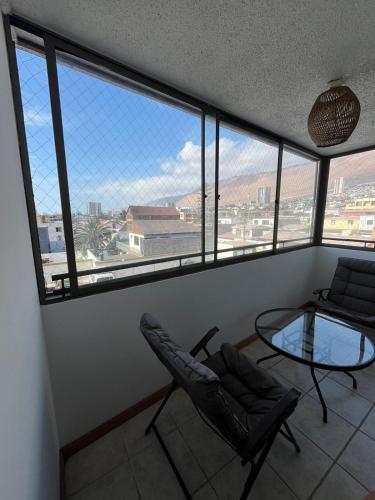 une chambre avec deux chaises et une table en verre dans l'établissement Reina Isidora, à Iquique