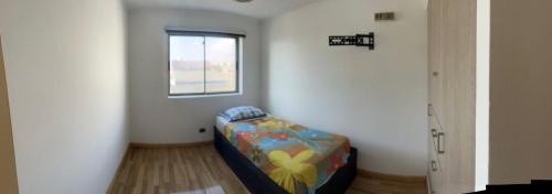 een kamer met een bed in een kamer met een raam bij Reina Isidora in Iquique