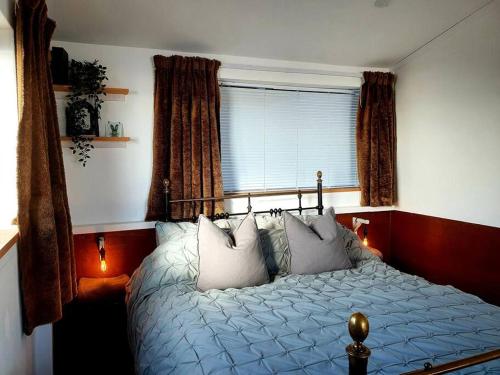 a bedroom with a bed with pillows and a window at The Studio at Stoodley Pike View in Todmorden