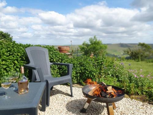 a fire pit next to a chair and a table at The Studio at Stoodley Pike View in Todmorden