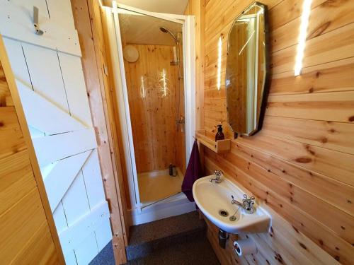 a bathroom with a sink and a shower and a mirror at The Studio at Stoodley Pike View in Todmorden