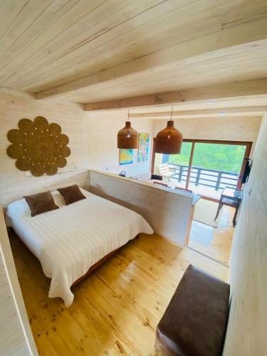 a bedroom with a white bed in a wooden room at Forest house Cabaña para 2 in Pichilemu