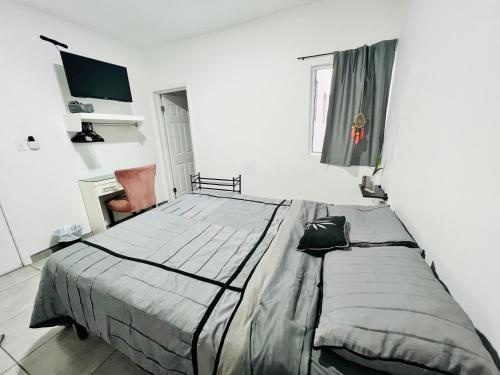 1 dormitorio con 1 cama grande en una habitación blanca en Casa Ambar, en Tijuana