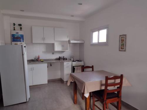 eine Küche mit einem Tisch und einem weißen Kühlschrank in der Unterkunft DTo CÉNTRICO LOBOS 1 C in Lobos