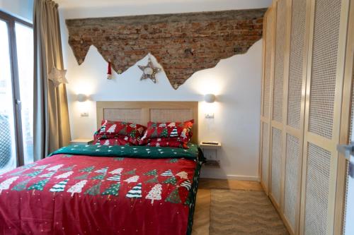 a bedroom with a red bed and a brick wall at Sweet cozy Ultracentral in Craiova