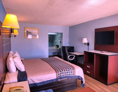 a hotel room with a bed and a desk at Rodeway Inn Richland - Jackson South in Richland