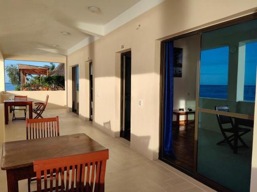 uma sala de estar com uma mesa e vista para o oceano em Blue Tides Hotel em Nungwi