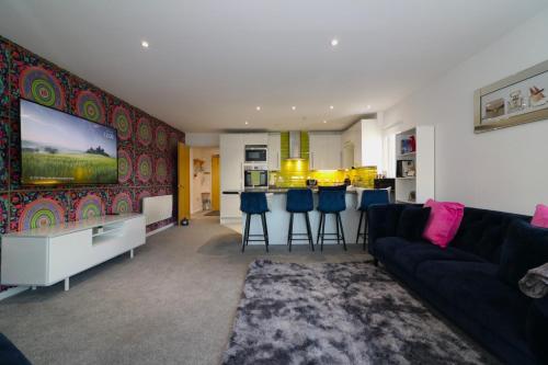 a living room with a couch and a tv at Glas-Go 2 bedroom Apartment 3 min walk to SECC Hydro FREE PARKING ONSITE in Glasgow