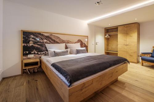 a bedroom with a large bed with a wooden headboard at Haus Bergheimat in Oberstdorf