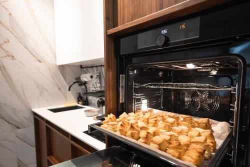 an oven with a tray of food in it at Glečer Kop, Cozy design apartment A5, FREE Parking Garage in Kopaonik