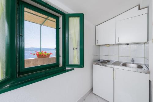 a kitchen with a window and a sink at Apartments Nada in Bol