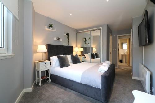 um quarto com uma grande cama branca e um espelho em Glas-Go 2 bedroom Apartment 3 min walk to SECC Hydro FREE PARKING ONSITE em Glasgow