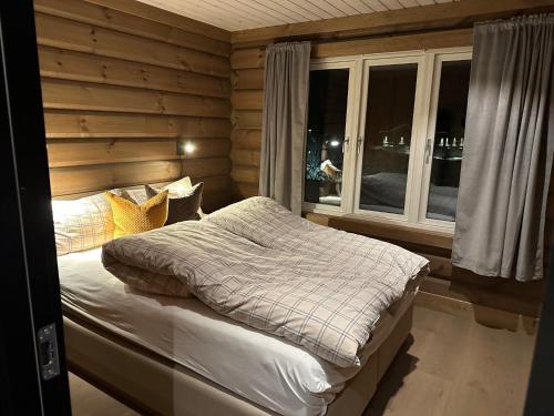 a bedroom with a bed in a room with windows at Årebjørnen - Sadelen in Åre