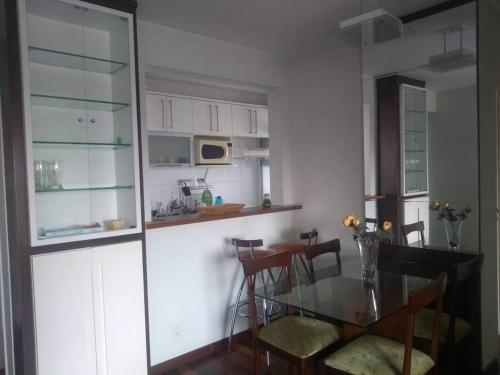 a kitchen with a glass table and some chairs at Próximo Parque Aclimação e Região da Paulista in Sao Paulo