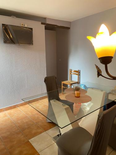 une salle à manger avec une table et des chaises en verre dans l'établissement Gîtes De La Levée, à Chouzé-sur-Loire