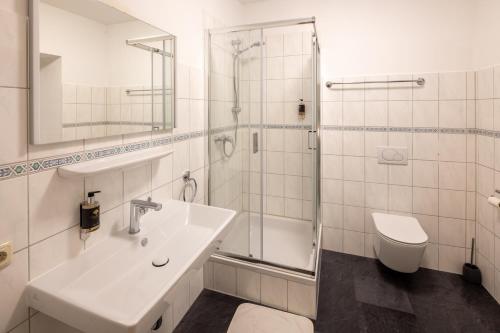メミンゲンにあるHotel Schwanenの洗面台、シャワー、トイレ付きのバスルーム