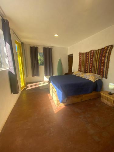 a bedroom with a bed with a blue comforter at La Sardina in Todos Santos