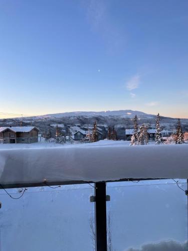 a snowboard on a railing with a view of a town at Årebjørnen - Sadelen in Åre