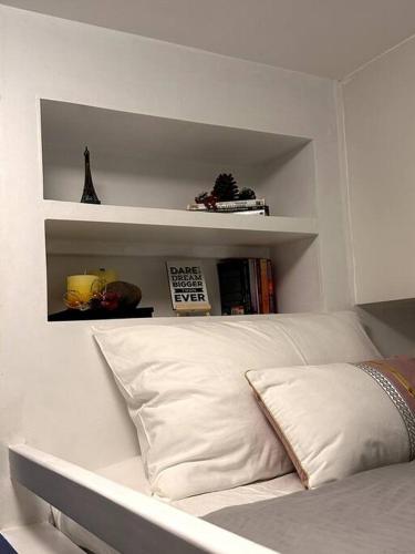 a white bedroom with a bed with white shelves at New & Spacious Unit in QC w/ Wifi & Netflix in Manila