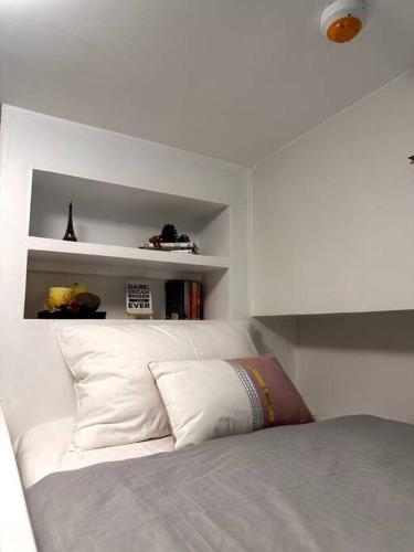 a bedroom with a bed with white walls and shelves at New & Spacious Unit in QC w/ Wifi & Netflix in Manila