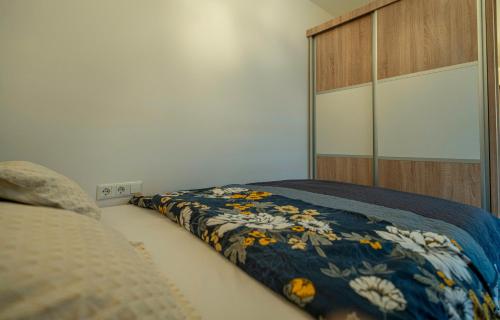 a bedroom with a bed with a blue comforter at Calendula apartments in Tuzla