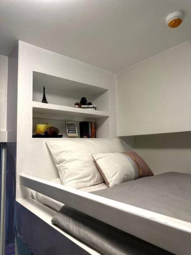 a bedroom with a bed with white walls and shelves at New & Spacious Unit in QC w/ Wifi & Netflix in Manila