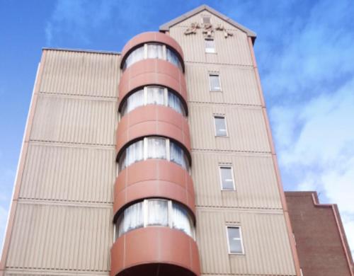 a tall building with a clock on top of it at YOU STYLE HOTEL MATE 鹿児島 天文館 in Kagoshima