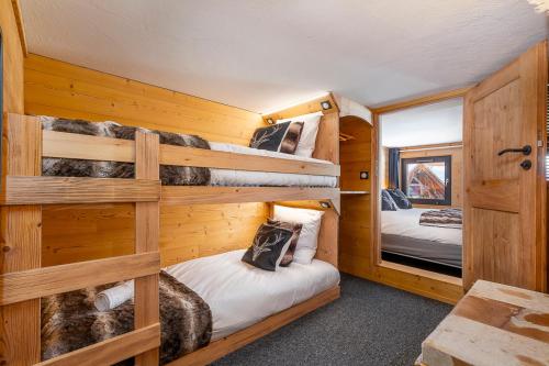 a bedroom with two bunk beds in a cabin at Val Thorens - Cosy Duplex Pied des pistes Silveralp 003 in Val Thorens