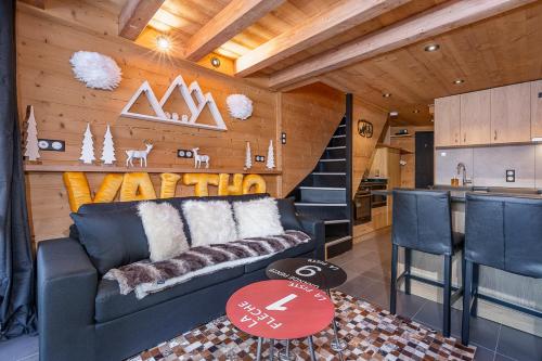 a living room with a couch and a kitchen at Val Thorens - Cosy Duplex Pied des pistes Silveralp 003 in Val Thorens