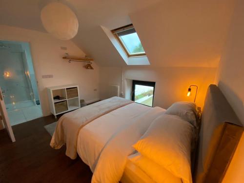 um quarto com uma grande cama branca e uma janela em Bill's Barns Apartment 2 em Kenmare