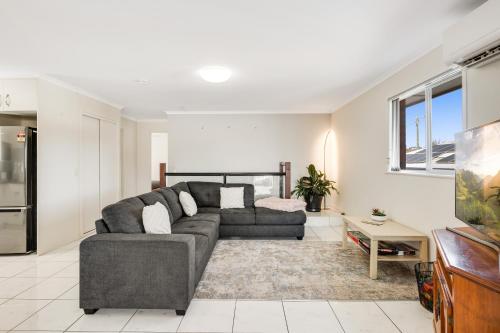 a living room with a couch and a table at Perfect CDB & Parkland Fringe! in Toowoomba