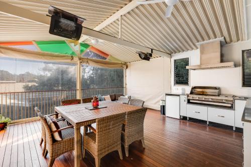 a living room with a table and a kitchen at Perfect CDB & Parkland Fringe! in Toowoomba